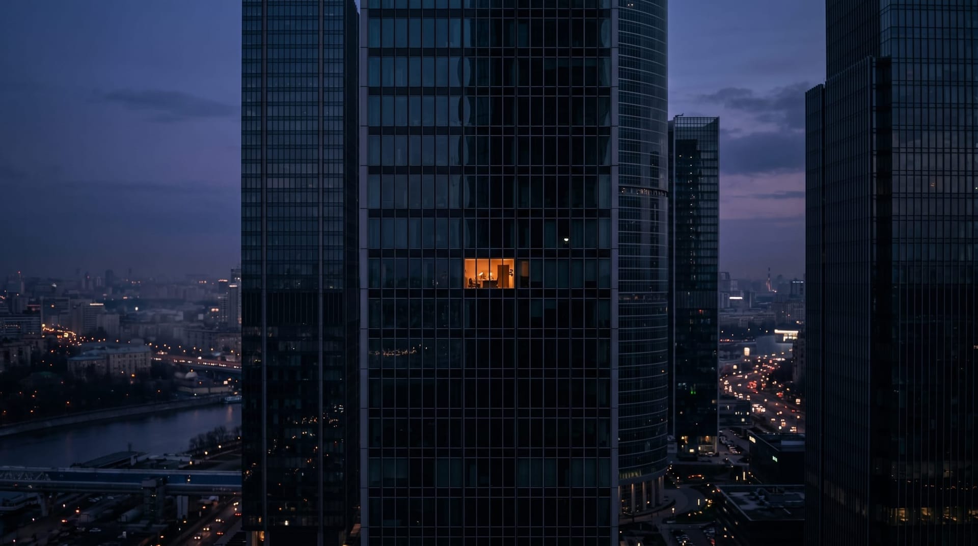 A single lit office window in a row of dark corporate high-rises at dusk, representing the small fraction of enterprises whose AI agents have cleared the trust bar to ship.